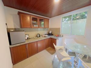 a kitchen with wooden cabinets and a table with chairs at Blackpool Hub in Nikawatawana