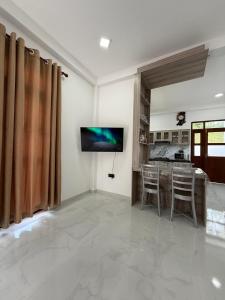 a living room with a television and a table and chairs at Southern Hight's Villa in Unawatuna