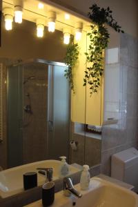 a bathroom with a sink with a mirror and a toilet at Monolocale Belvedere in La Thuile