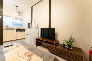 a living room with a television and a table at JPtrad 葵 なんばや心斎橋にも直結の8名様まで宿泊可能の広々メゾネット in Osaka