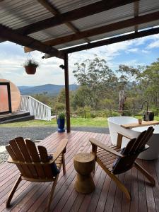 a deck with two chairs and a tub and a table at Romantic Stargazing Dome - Beyond Bubbles in Kulnura