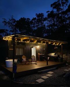 a pergola with lights on a deck at night at Romantic Stargazing Dome - Beyond Bubbles in Kulnura +9 photos