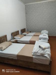 a group of four beds in a room at TOPTEN Hotel Tashkent in Yalanghoch