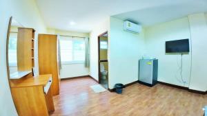 a room with a desk and a refrigerator in it at เอสดี ดี พี อพาร์ทเม้นต์ in San Kamphaeng