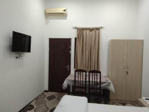a room with a table and two chairs and a television at TOPTEN Hotel Tashkent in Yalanghoch