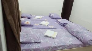 a purple bed with purple sheets and pillows on it at TOPTEN Hotel Tashkent in Yalanghoch +4 photos