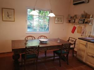 a kitchen with a wooden table and chairs and a window at Villa with big garden in Athens