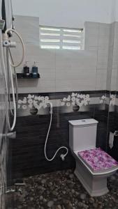 a bathroom with a toilet with a pink seat at Simple Place in Mirissa +33 photos