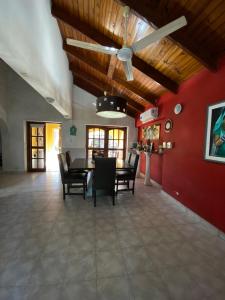 a dining room with a ceiling fan and red walls at Casa Mitre en El Paso in Paso de la Patria +4 photos