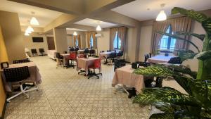 a waiting room with tables and chairs and a plant at Moda Hotel in Kırklareli