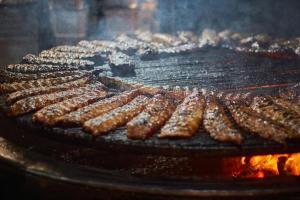 a bunch of sausages cooking on a grill at Mary Apartments in Stalís