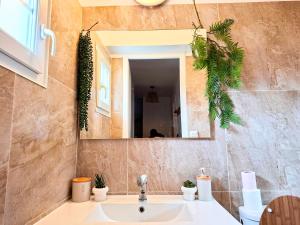 a bathroom with a sink and a mirror at Maison 3 chambres - 6-8 personnes - piscine chauffée - jacuzzi - internet - parking - Idéal familles & pros in Monflanquin