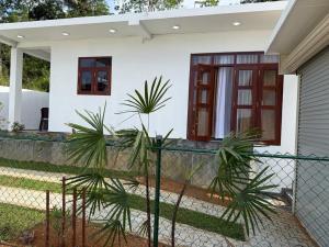 a house with a fence and palm trees in front of it at Southern Hight's Villa in Unawatuna +5 photos