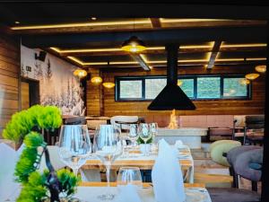 a restaurant with white tables and chairs and windows at Prestige Lux Andan - Apart hotel Horizont Jahorina in Jahorina