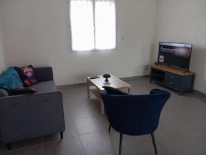 a living room with a couch and a table and a tv at Loire et Vignes in Saint-Bouize