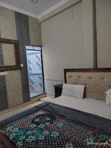 a bedroom with a bed and a window at Raghunandan dham in Chitrakoot