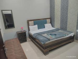 a bedroom with a bed in a room with a mirror at Raghunandan dham in Chitrakoot