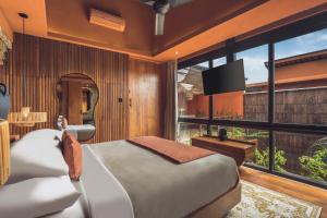 a bedroom with a bed and a large window at Sana Vie Villa Seminyak by Ini Vie Hospitality in Seminyak +26 photos