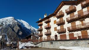 a building with balconies and a mountain in the background at Trilocale BELVEDERE Alloggio ad uso turistico - VDA - LA THUILE - CIR 0068 in La Thuile