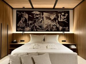 a bedroom with a large bed with a painting on the wall at Bocca al Lupo Villas in Kato Loutraki +59 photos