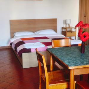 a bedroom with a large bed and a table with a table sidx sidx at Student's Hostel Della Ghiara in Reggio Emilia