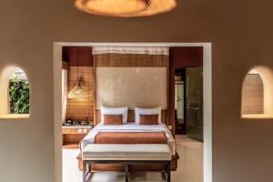 a bedroom with a king sized bed and a bathroom at Seminyak Sanctuary Villa by Ini Vie Hospitality in Seminyak