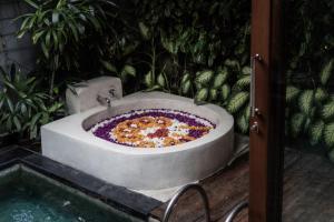a large pizza in a bath tub in a garden at Seminyak Sanctuary Villa by Ini Vie Hospitality in Seminyak