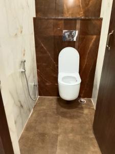 a bathroom with a white toilet in a stall at Hotel Gulmohar Tree in Jāmb +10 photos