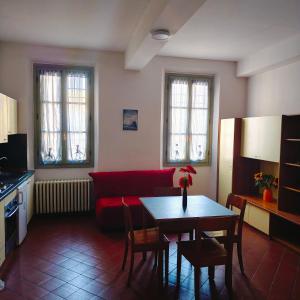 a living room with a red couch and a table at Student's Hostel Della Ghiara in Reggio Emilia