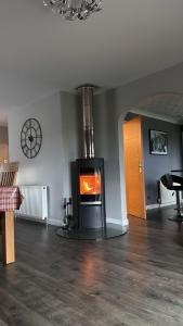 a living room with a fireplace in the middle of a room at Gleneden House in Tore