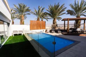 a swimming pool in a yard with palm trees at villalis bay view in Eilat