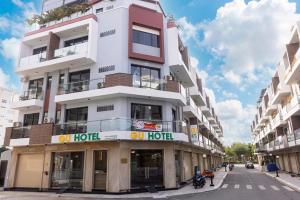 a tall white building with a sign on it at Gu Boutique Hotel - Central Phan Rang in Phan Rang–Tháp Chàm