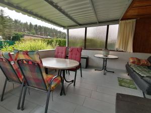 a patio with a table and chairs and a couch at Bungalow am Ferchesarer See in Ferchesar
