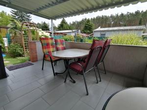 a table and chairs sitting on a patio at Bungalow am Ferchesarer See in Ferchesar +12 photos