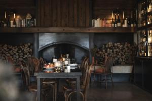a table and chairs in a room with a fireplace at Auberge de la Roche in Valdeblore
