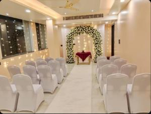 a wedding aisle with white chairs and an altar at Hotel Gulmohar Tree in Jāmb
