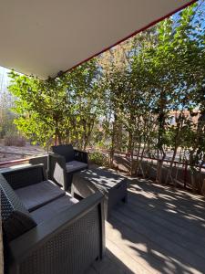 a patio with chairs and tables and trees at Le Cocon Nîmois in Nîmes