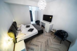 a living room with a bed and a television at Sunrise Rooms in Bucharest