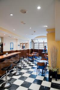 a restaurant with tables and chairs on a checkered floor at Hotel Cordón in Burgos