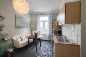 a kitchen with a sink and a table and a chair at N&N Altbau-Apartments Schwerin nähe Schloss & Zentrum in Schwerin