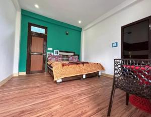 a room with two beds and a green wall at Majestic House , Kalga , Kalgha in Kalgha
