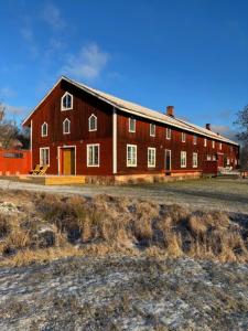 a large red barn sitting on the side of a field at Ladugårdens Pub & Sal in Enhörna