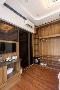a room with a tv and a room with wooden floors at Gu Boutique Hotel - Central Phan Rang in Phan Rang–Tháp Chàm