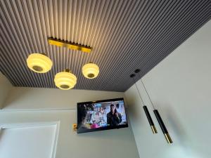 a room with three lights and a tv on the ceiling at G - Boutique in Durban