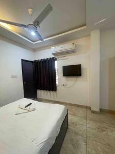 a bedroom with a white bed and a air conditioner at Hotel shree shiv in Indore