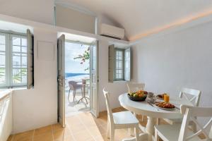 a kitchen and dining room with a table and chairs at Mardanza Krokos Suites in Imerovigli