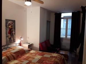a bedroom with a bed and a window at Mason d'hôtes La re'belle in Céret