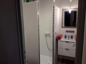 a white bathroom with a shower and a sink at Mason d'hôtes La re'belle in Céret