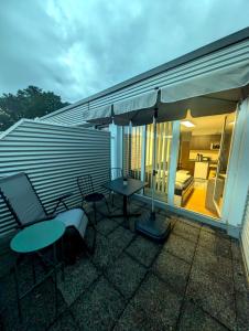 a patio with a table and chairs and an umbrella at Entspannen in Passau an der Donau inklusive Netflix in Passau