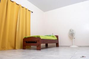 a room with yellow curtains and a bed and a fan at Rijsdijk appartementen in Lelydorp